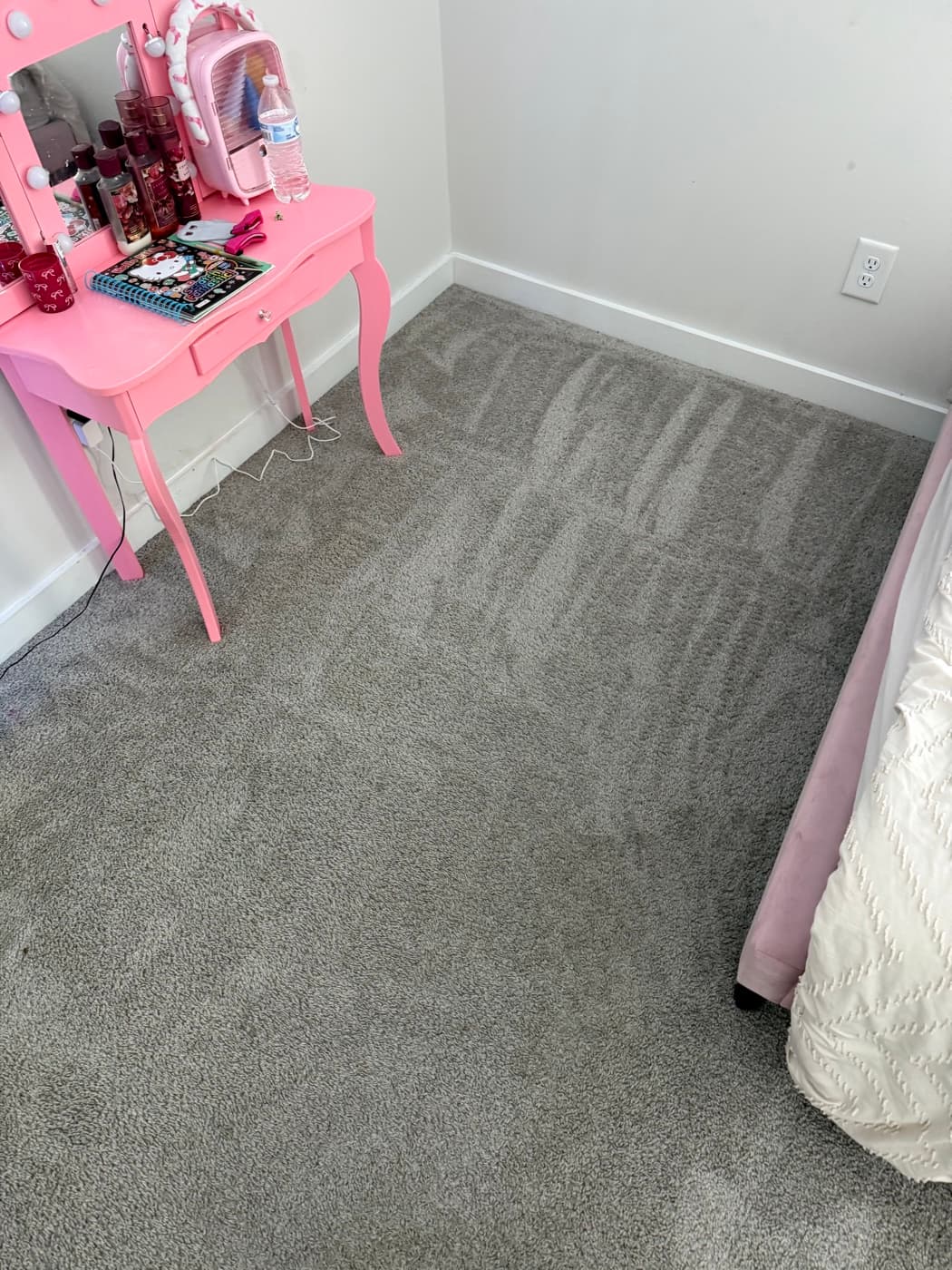 The same bedroom carpet after cleaning, with fresh vacuum lines across the pile