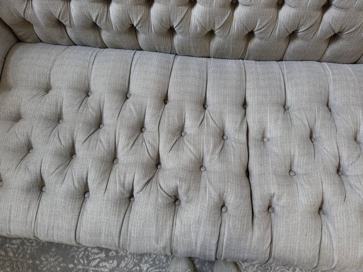 The same cream buttoned sofa back after steam cleaning