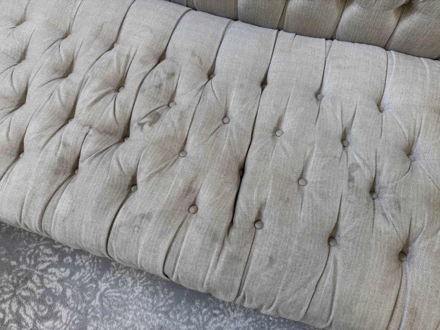 A cream buttoned sofa back, before cleaning