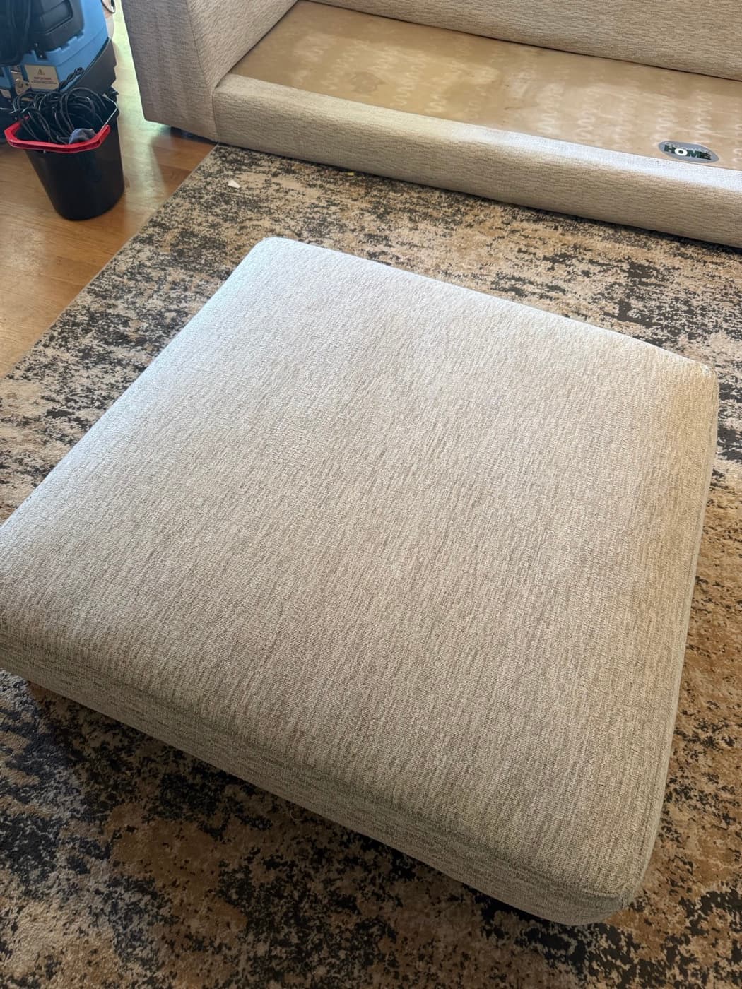 The same cream ottoman after steam cleaning