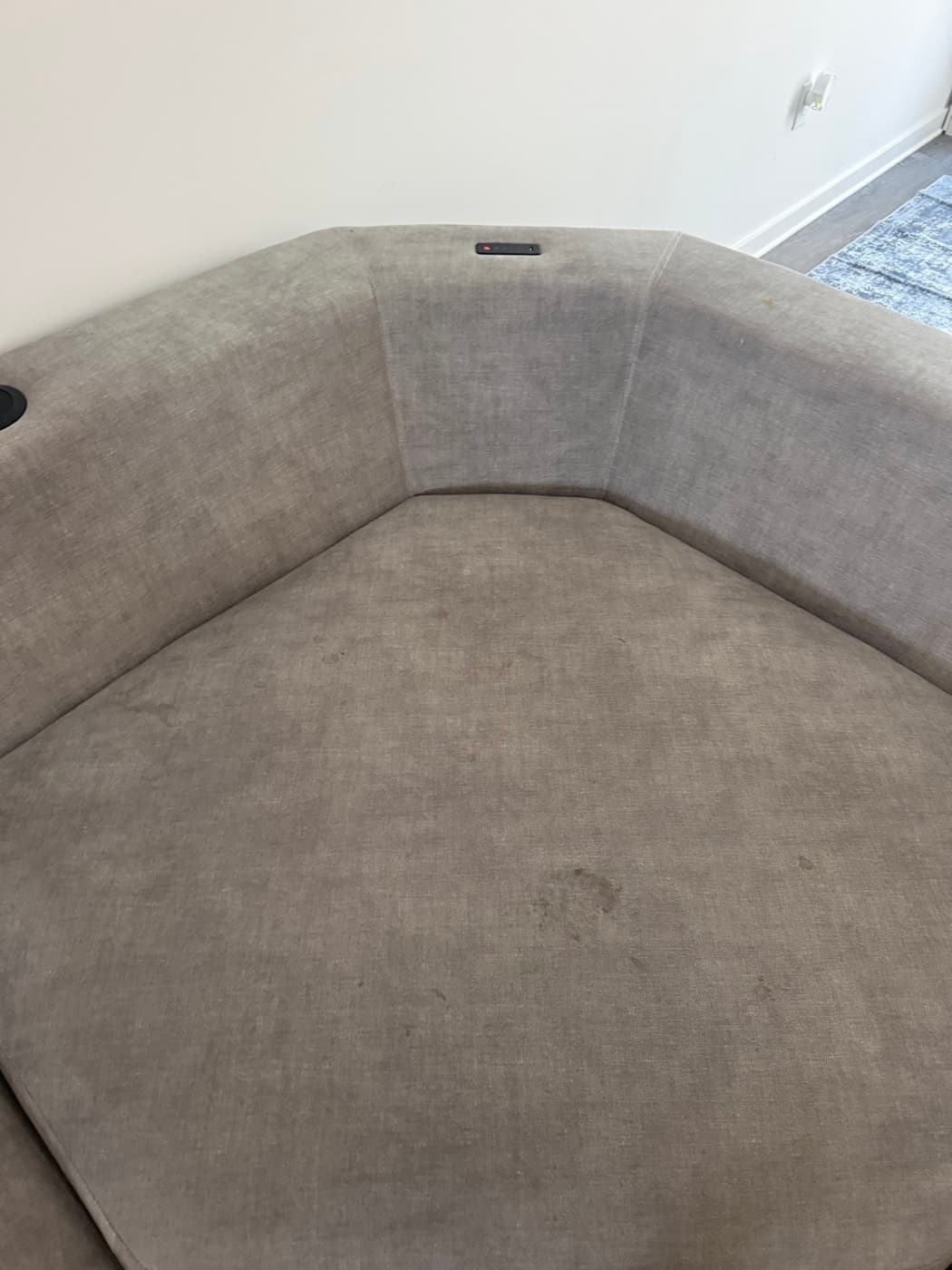 A beige sofa back with a dark stain, before cleaning