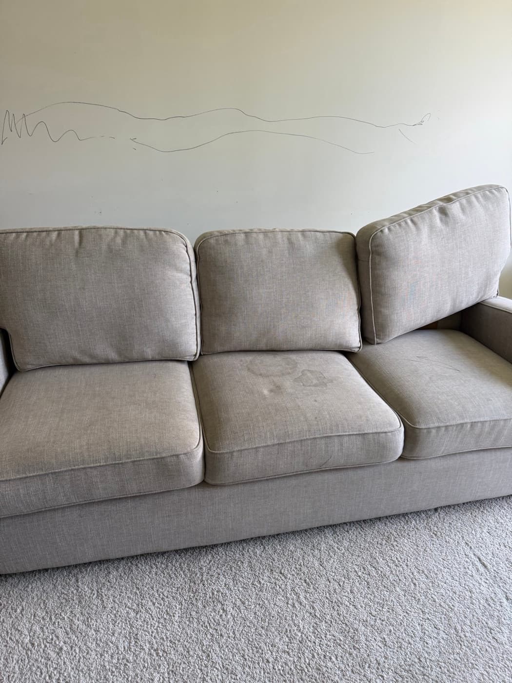 A cream three-seat sofa, before cleaning