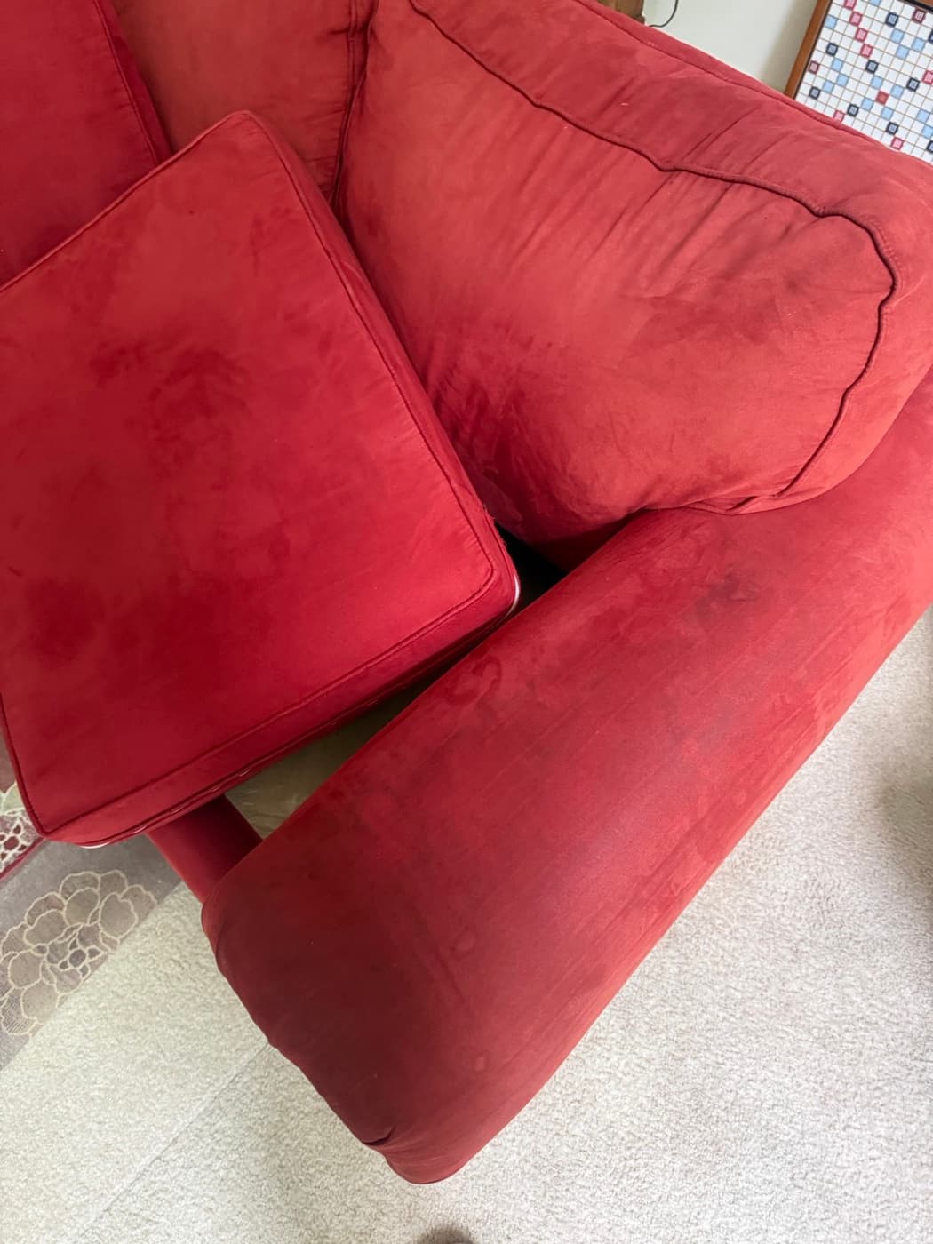 A red fabric recliner armchair, before cleaning