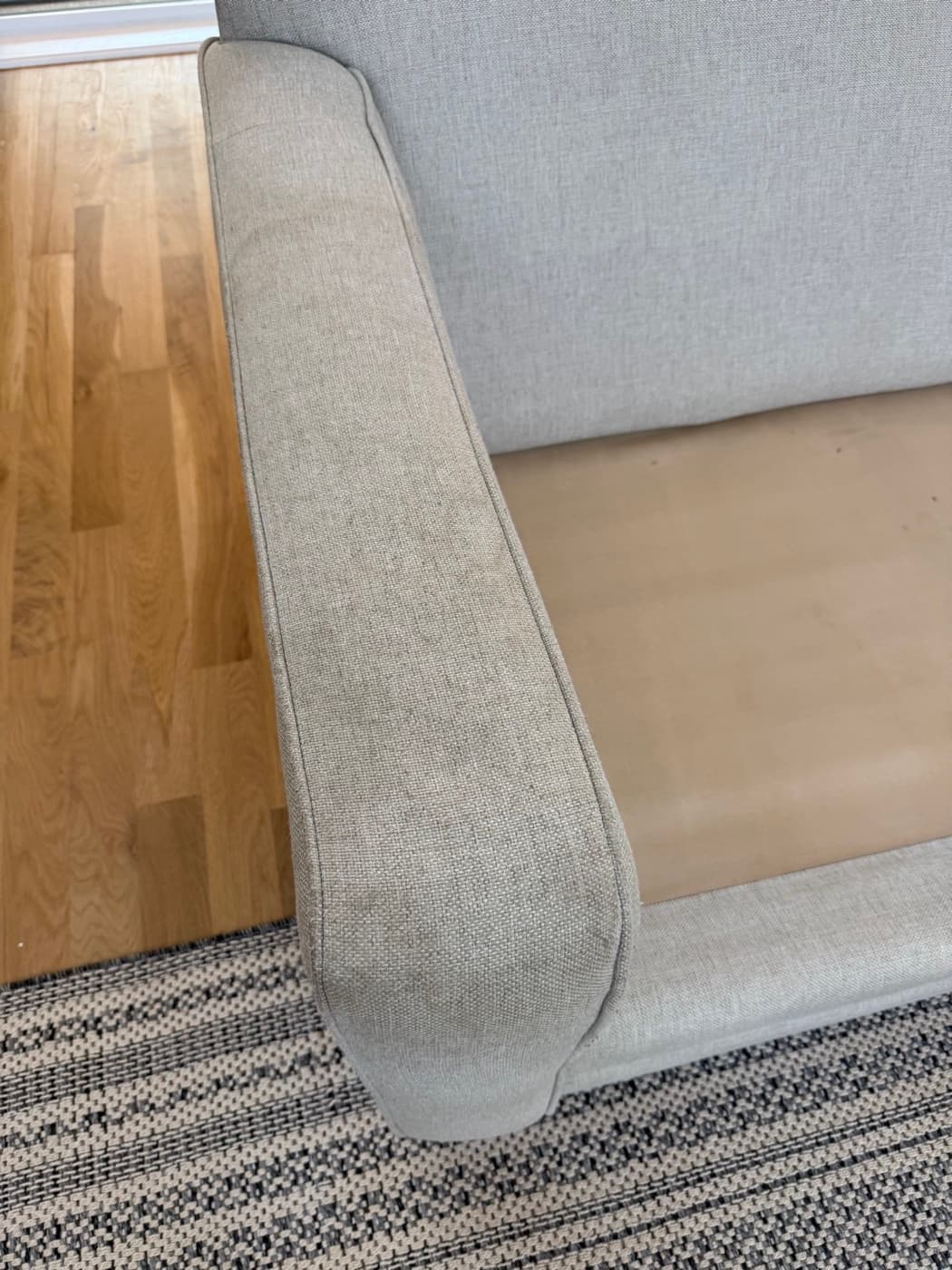 A grey chaise arm and seat, before cleaning