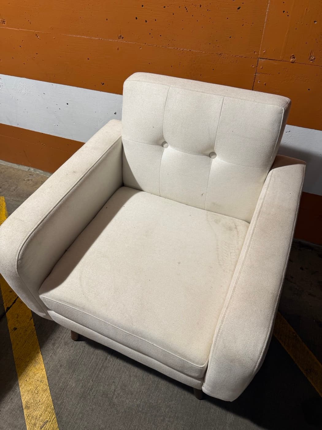 A cream buttoned chair, before cleaning