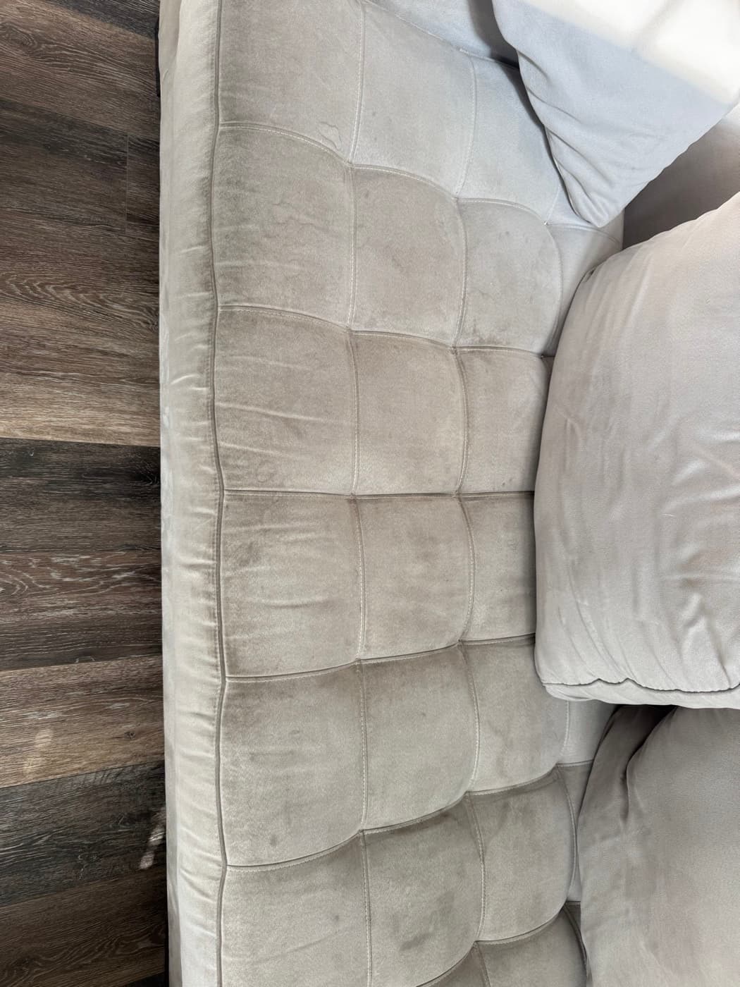 A cream tufted sofa seat, before cleaning